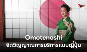 ผู้หญิงญี่ปุ่นสวมชุดกิโมโนสีเขียว นั่งอยู่หน้าฉากธงชาติญี่ปุ่น แสดงถึงจิตวิญญาณการบริการแบบ Omotenashi